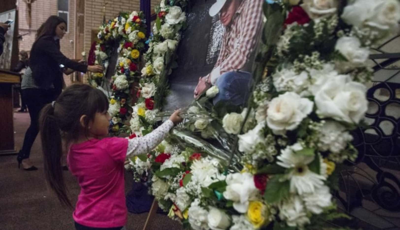 Una niña deja flores durante un servicio funeral en Los Ángeles por la muerte del cantante...