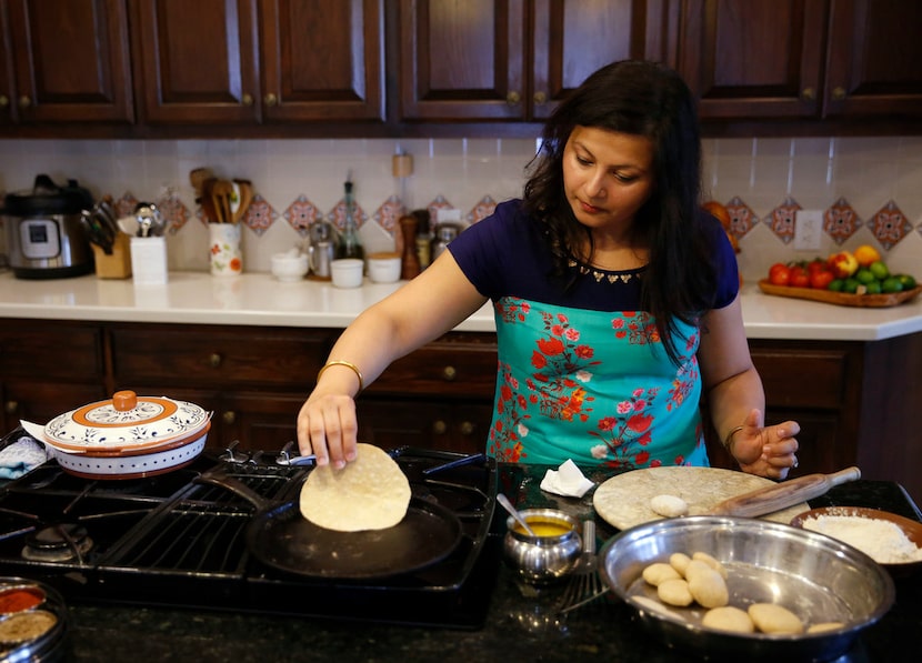 Sapna Punjabi-Gupta flips a roti at her home in Irving.