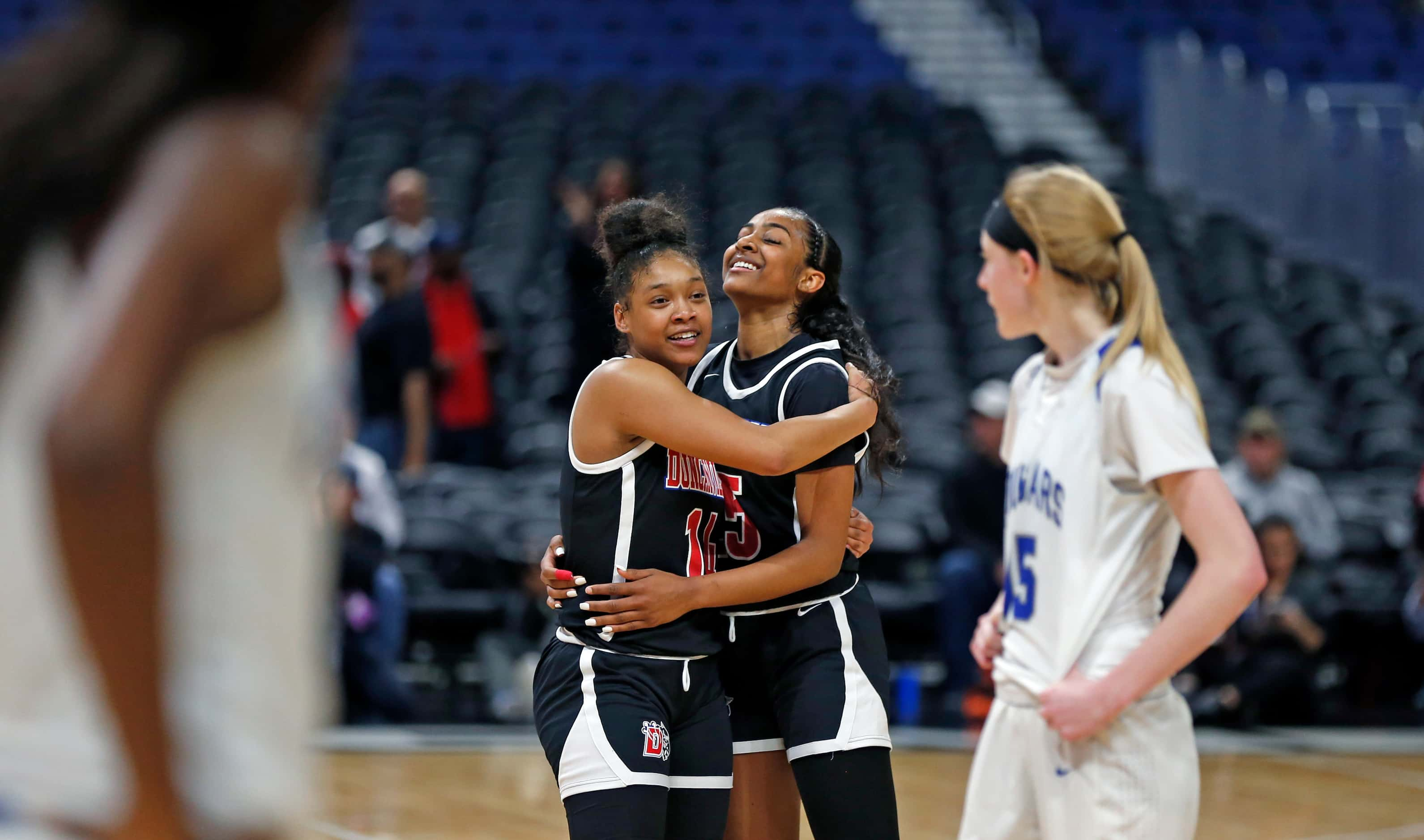 Duncanville guard Tristen Taylor #11 gets a hug from Duncanville guard Deja Kelly #25 as...