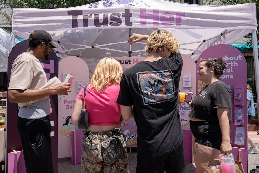 A steady stream of interested people stopped at the Trust Her booth Sunday to pick up birth...