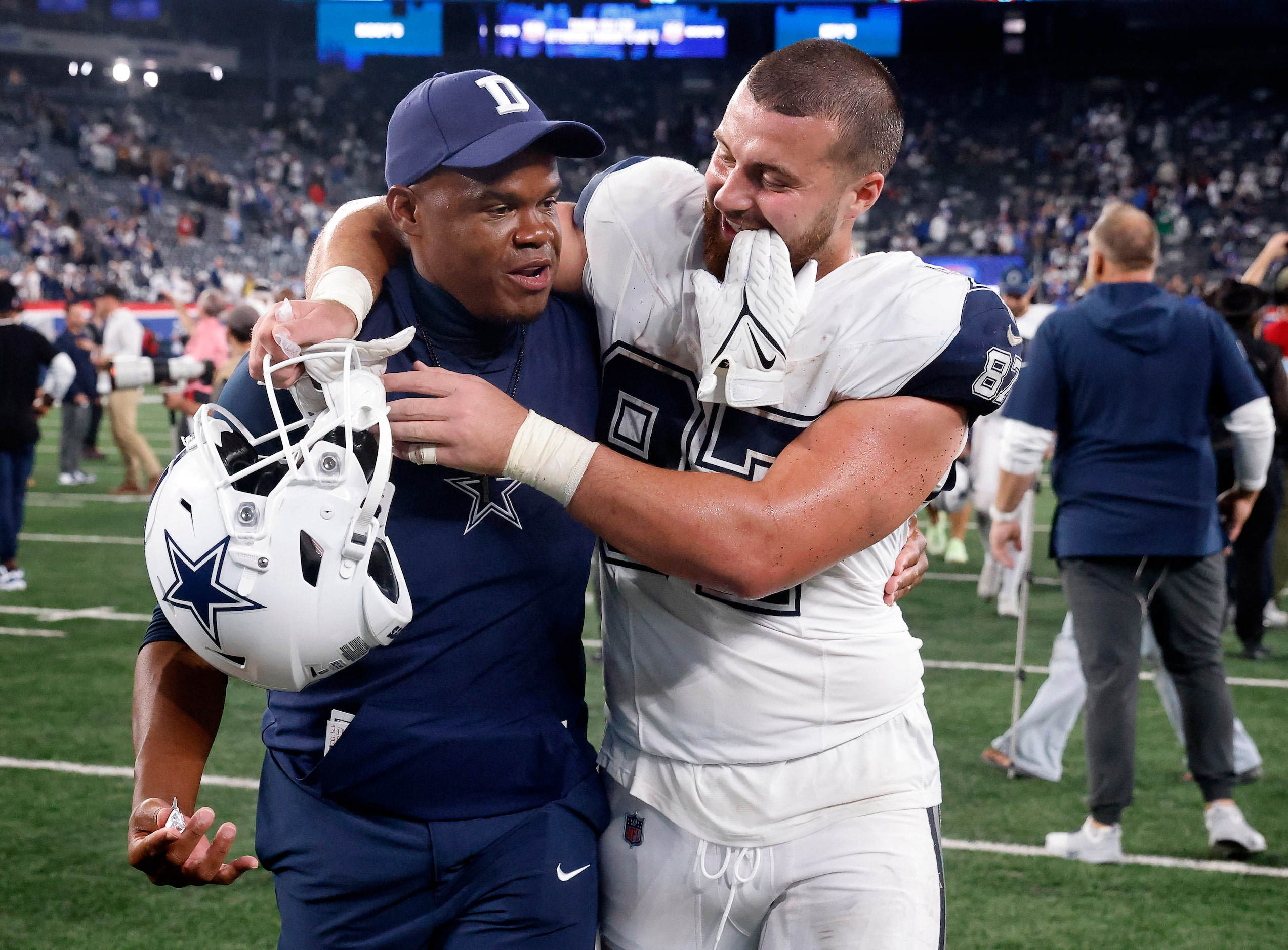 Dallas Cowboys tight end Jake Ferguson (87) hugs tight ends coach Lunda Wells as they walk...