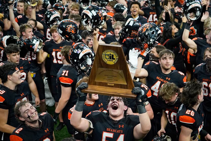 Aledo offensive lineman Rocco O'Keefe (54) hoists the championship trophy as the Bearcats ...