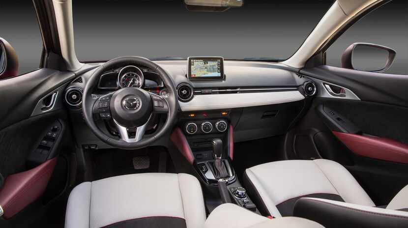 Inside the 2016 Mazda CX-3,  the dashboard wraps sleekly around the base of the windshield,...