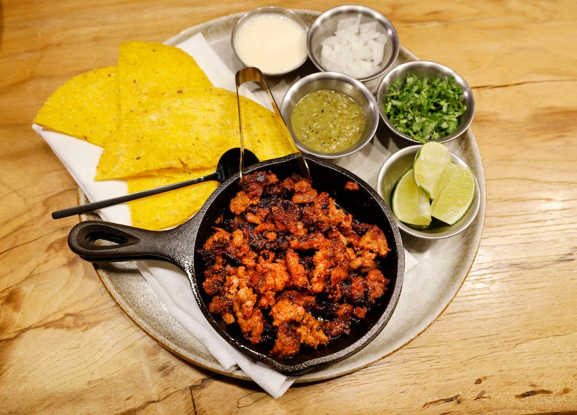 A plate of arepjitas, pastor pork with pineapple-onions and honduran crema, is seen at Rye...