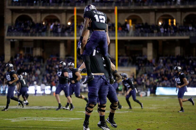 TCU Horned Frogs wide receiver Derius Davis (12) is lifted into the air by center Chris...