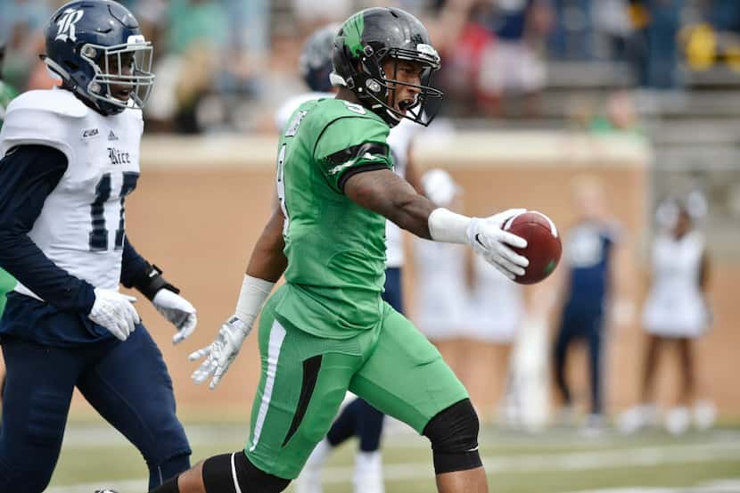 North Texas senior wide receiver Carlos Harris (9) holds the ball out as he enters the end...