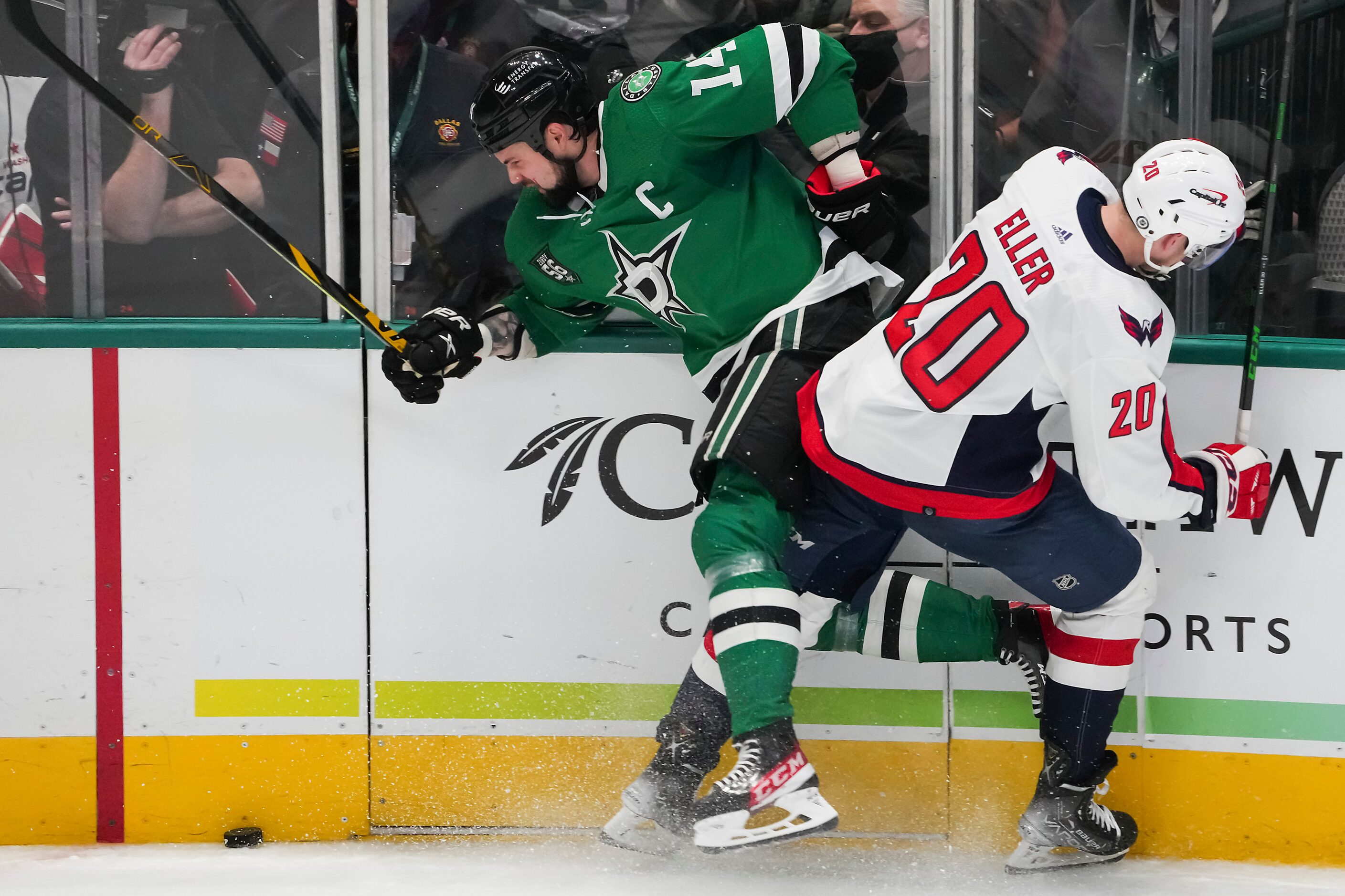 Dallas Stars left wing Jamie Benn (14) is checked by Washington Capitals center Lars Eller...