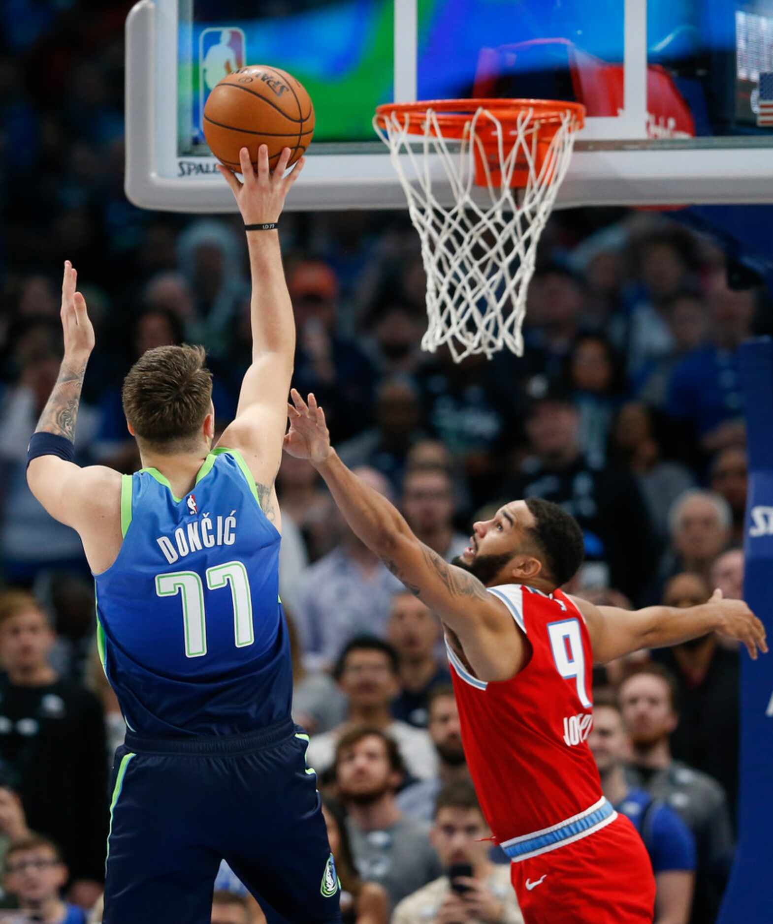 Dallas Mavericks forward Luka Doncic (77) puts up a shot over Sacramento Kings guard Cory...