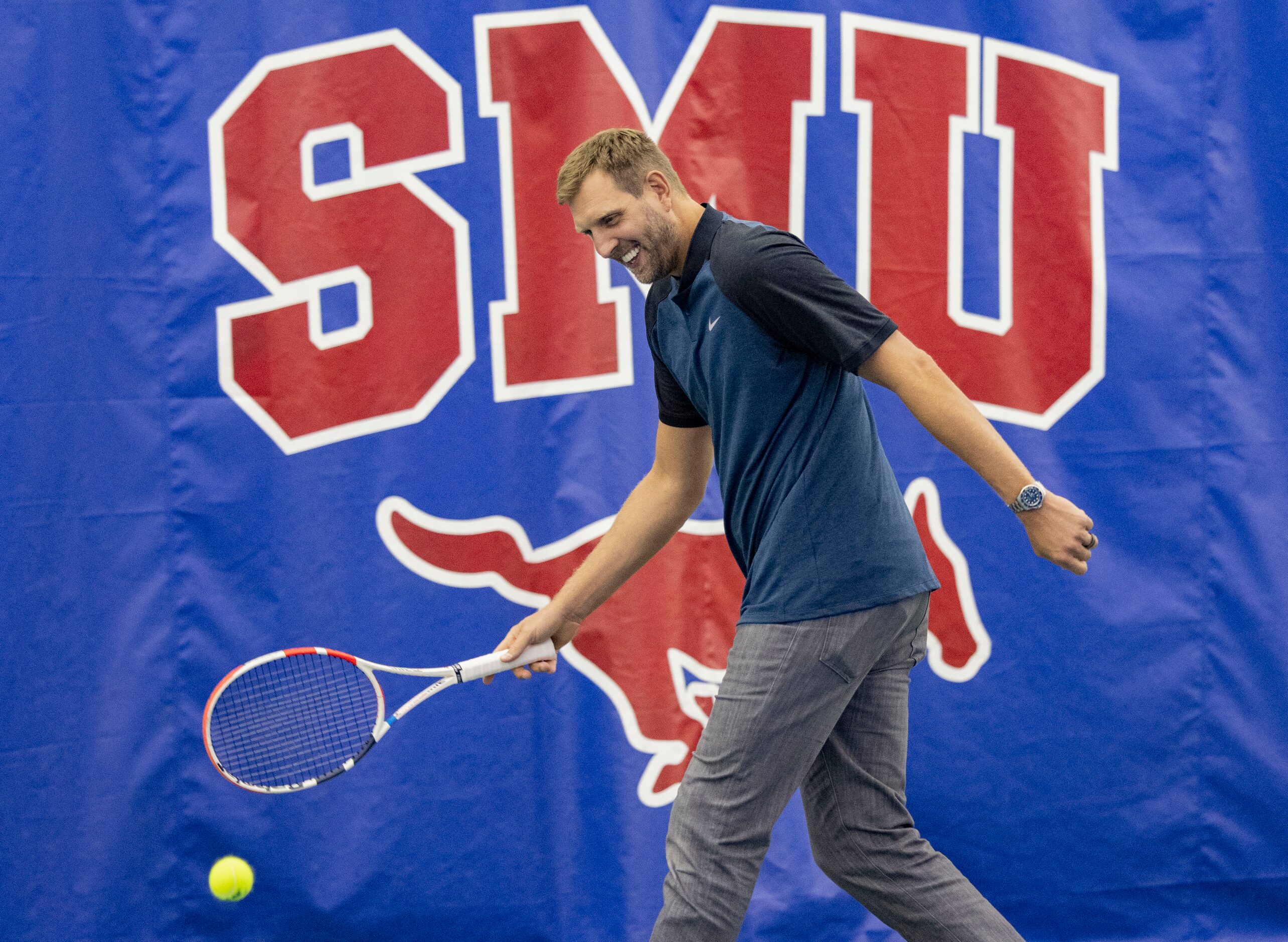 Dallas Mavericks star Dirk Nowitzki hits the tennis ball to John Isner, 15-Time ATP Tour...