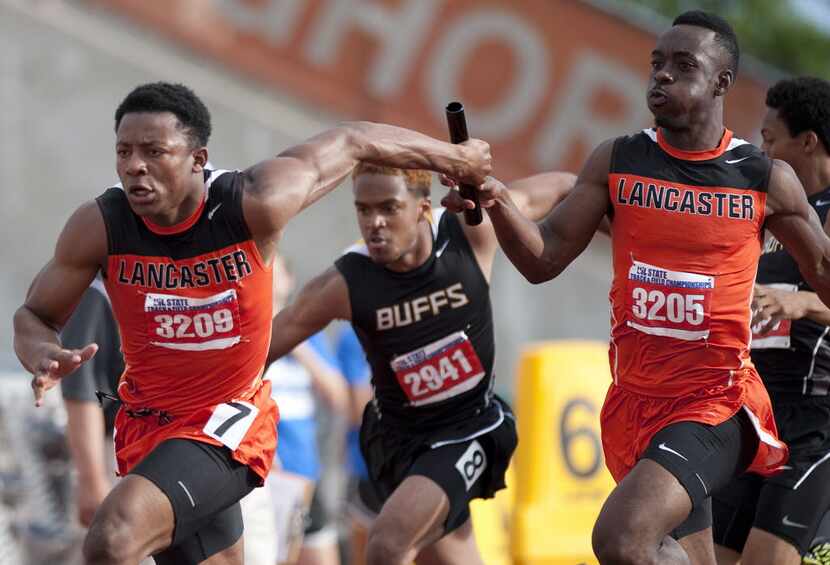 Lancaster's Kenan Ivy, left, grabs the baton from team mate Elijah Boyd, right, during the...