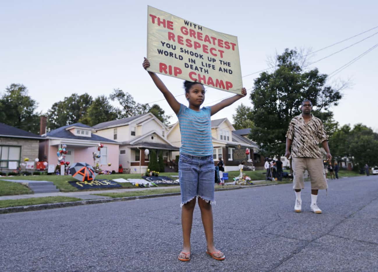 Akera Price-King, 9, carried a sign saluting Muhammad Ali on the street in front of Ali's...