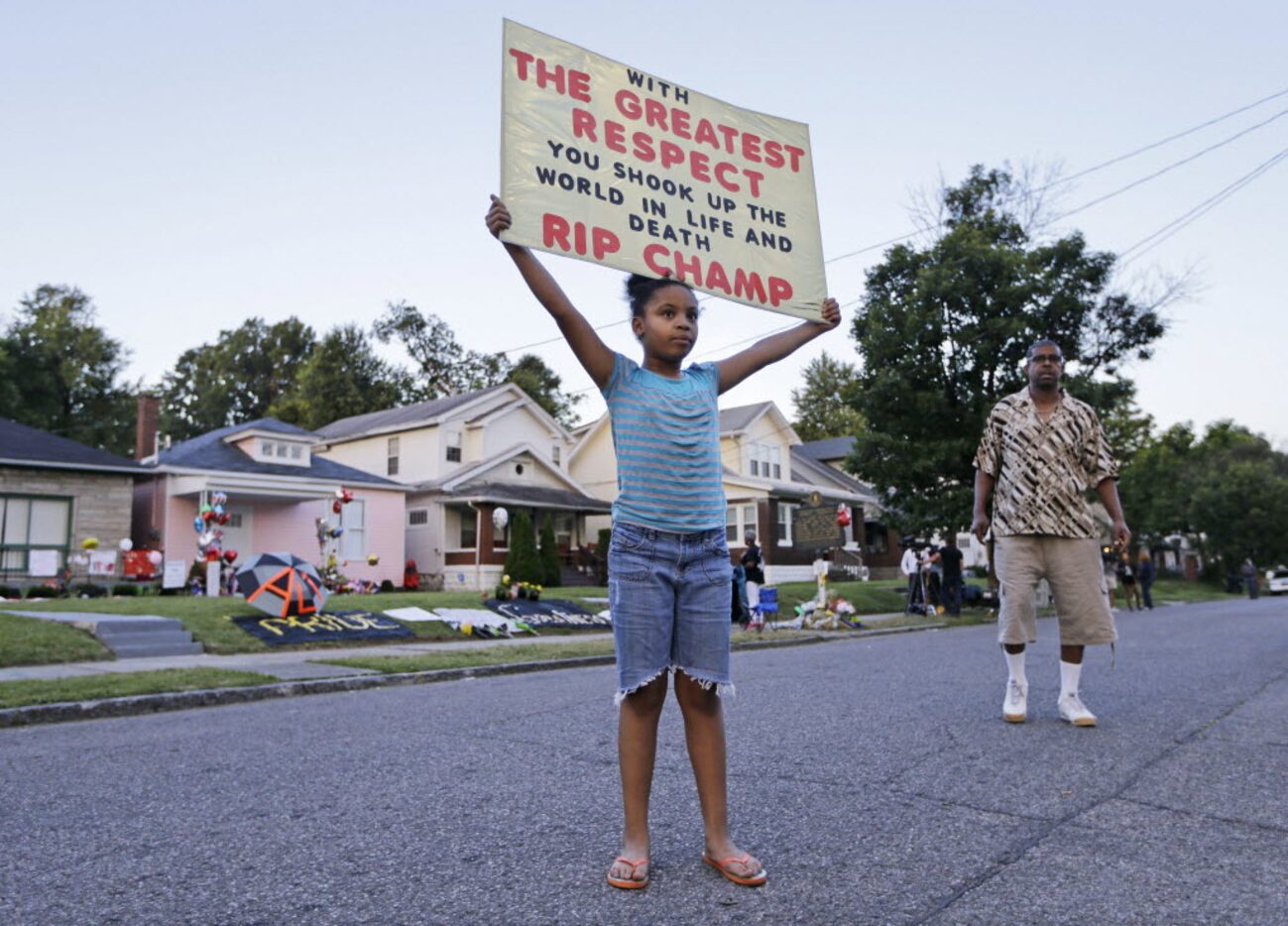 Akera Price-King, 9, carried a sign saluting Muhammad Ali on the street in front of Ali's...