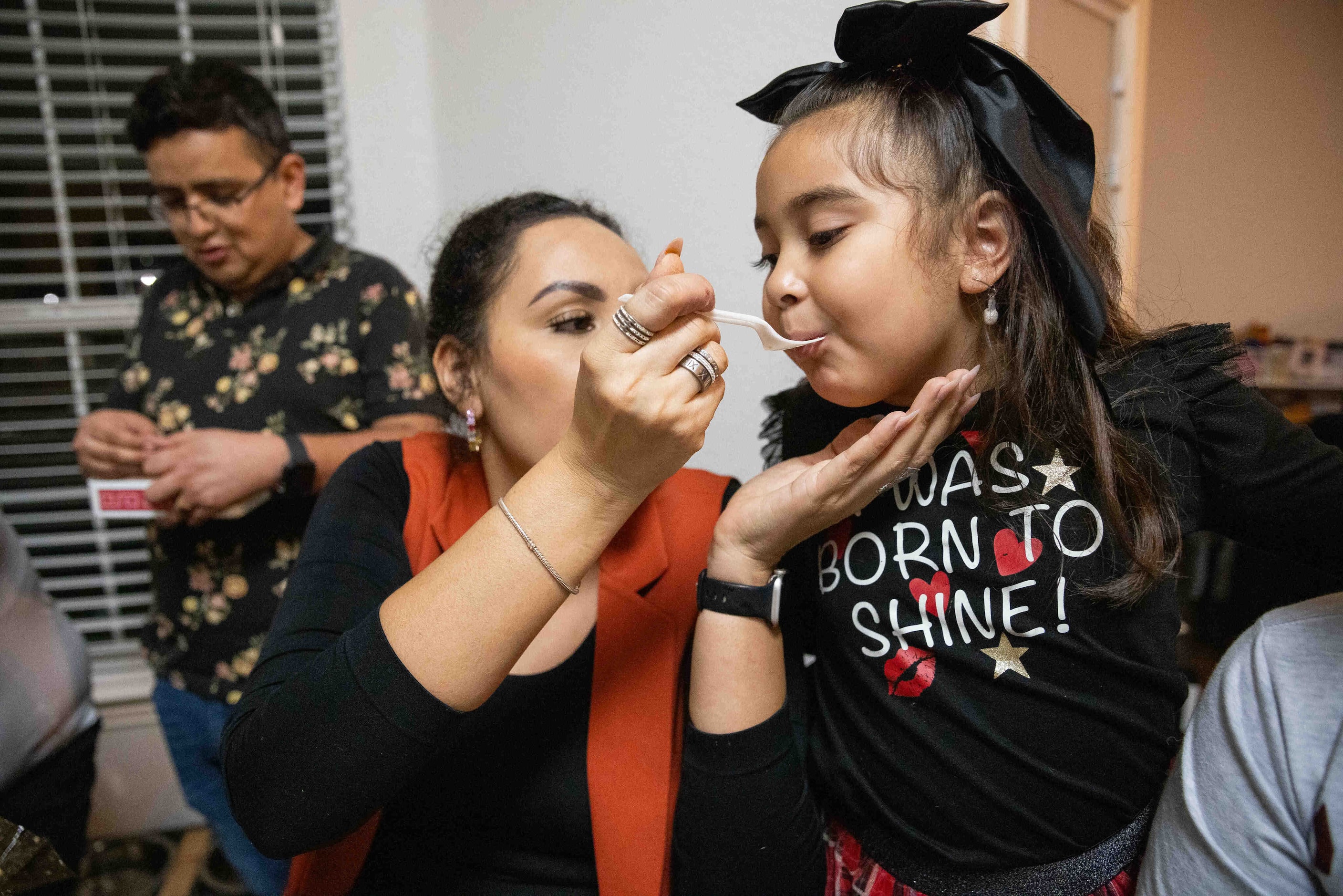 (From left)  Paola Lozoya of Chihuahua feeds her daughter Karla Ramos a tamale made by Sara...