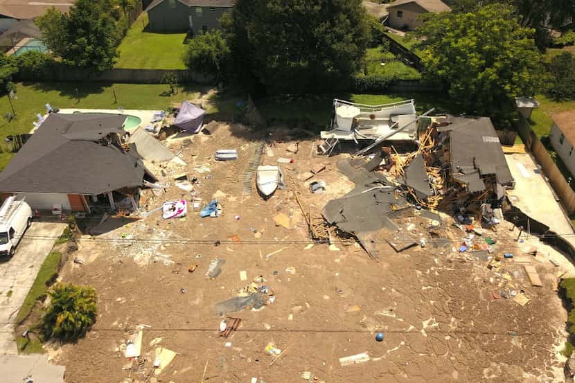In this aerial photo, debris is strewn about after a sinkhole damaged two homes in Land O'...