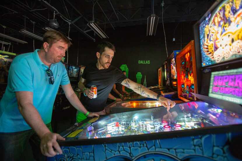 Jimmy Williams (left) and Elijah Riess (right) play an Aerosmith pinball machine during the...