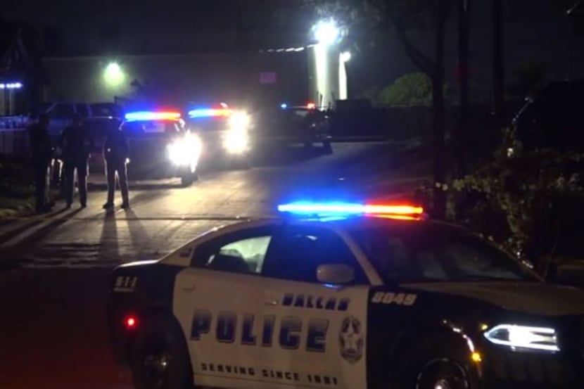 Dallas police gather near a home in West Dallas that was the site of a double shooting...