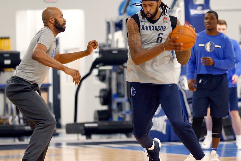 Dallas Mavericks center DeAndre Jordan drives past assistant coach Jamahl Mosley at their...