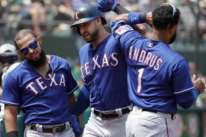 Texas Rangers' Joey Gallo, center, is congratulated by Rougned Odor, left, and Elvis Andrus...