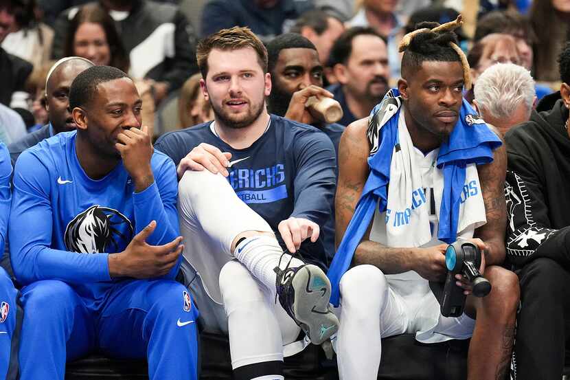 Dallas Mavericks guard Luka Doncic (center-left) watches from the bench during the first...