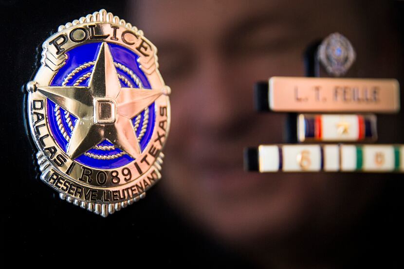 Larry Feille reflected in a plaque commemorating his 20 years as a Dallas Police Reserve...