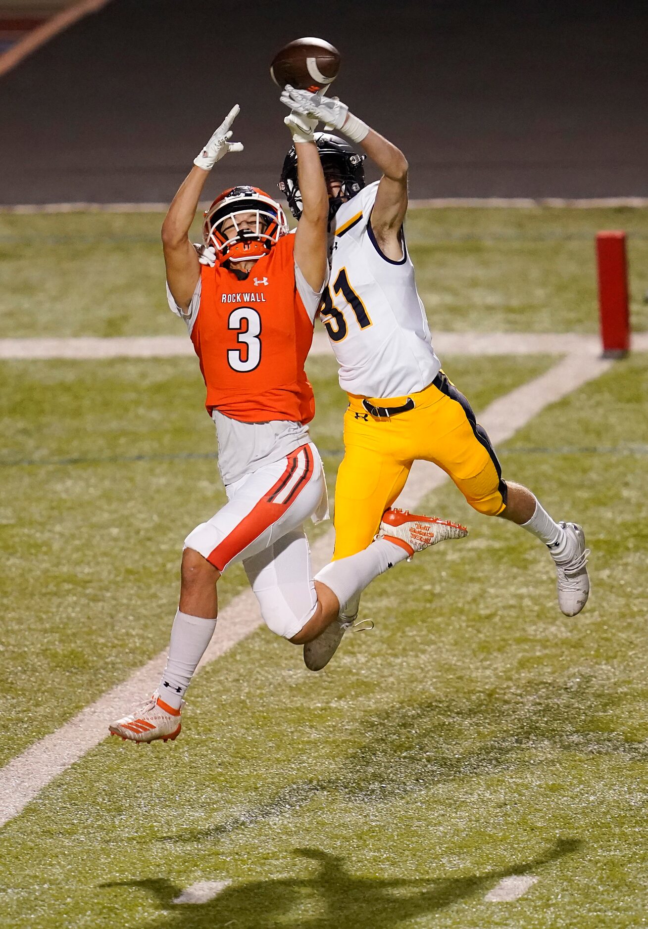 Highland park defensive back Blake Bevans (31) breaks up a pass intended for Rockwall wide...