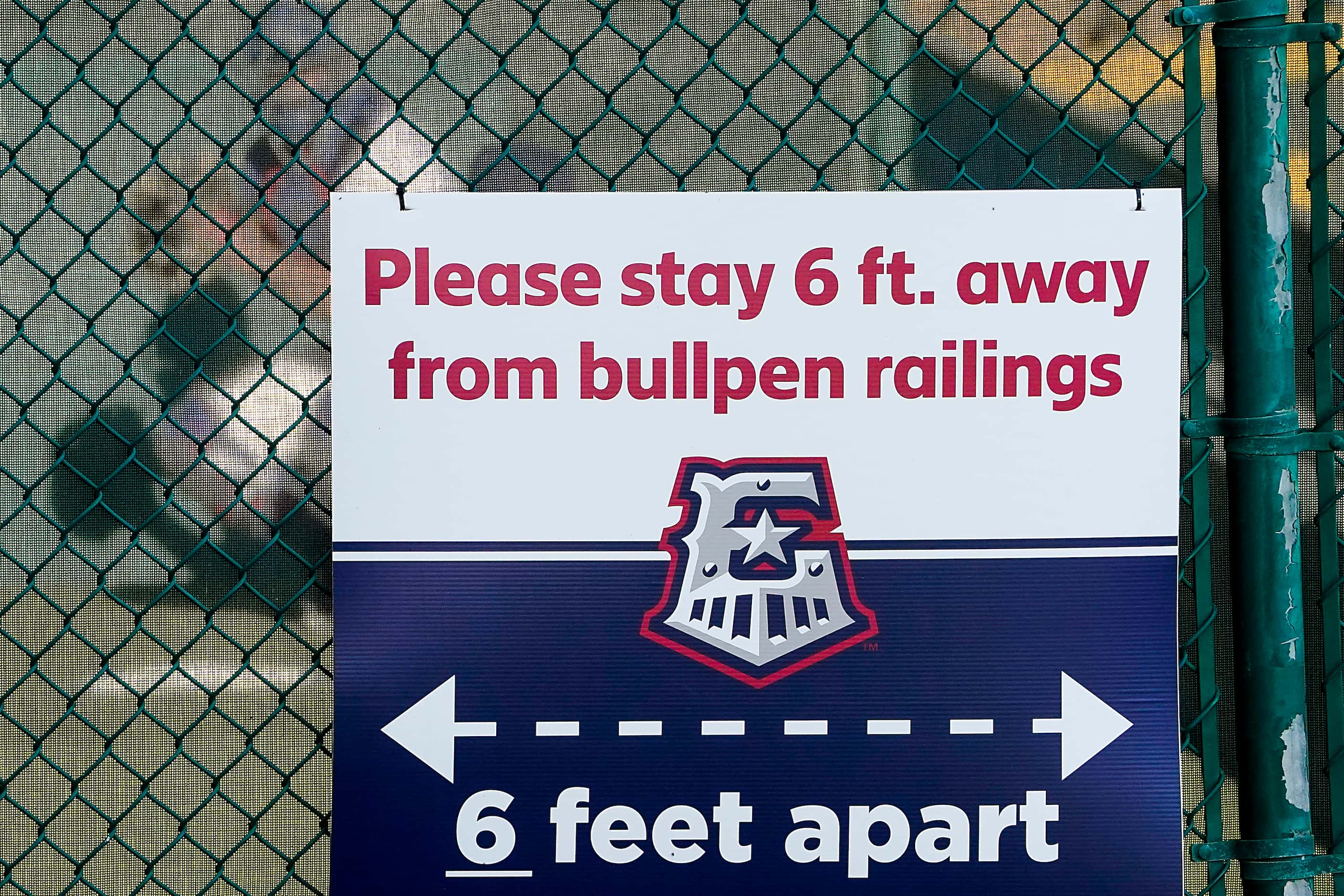 Signs at Dell Diamond encourage fans to keep social distancing from the bullpen before the...
