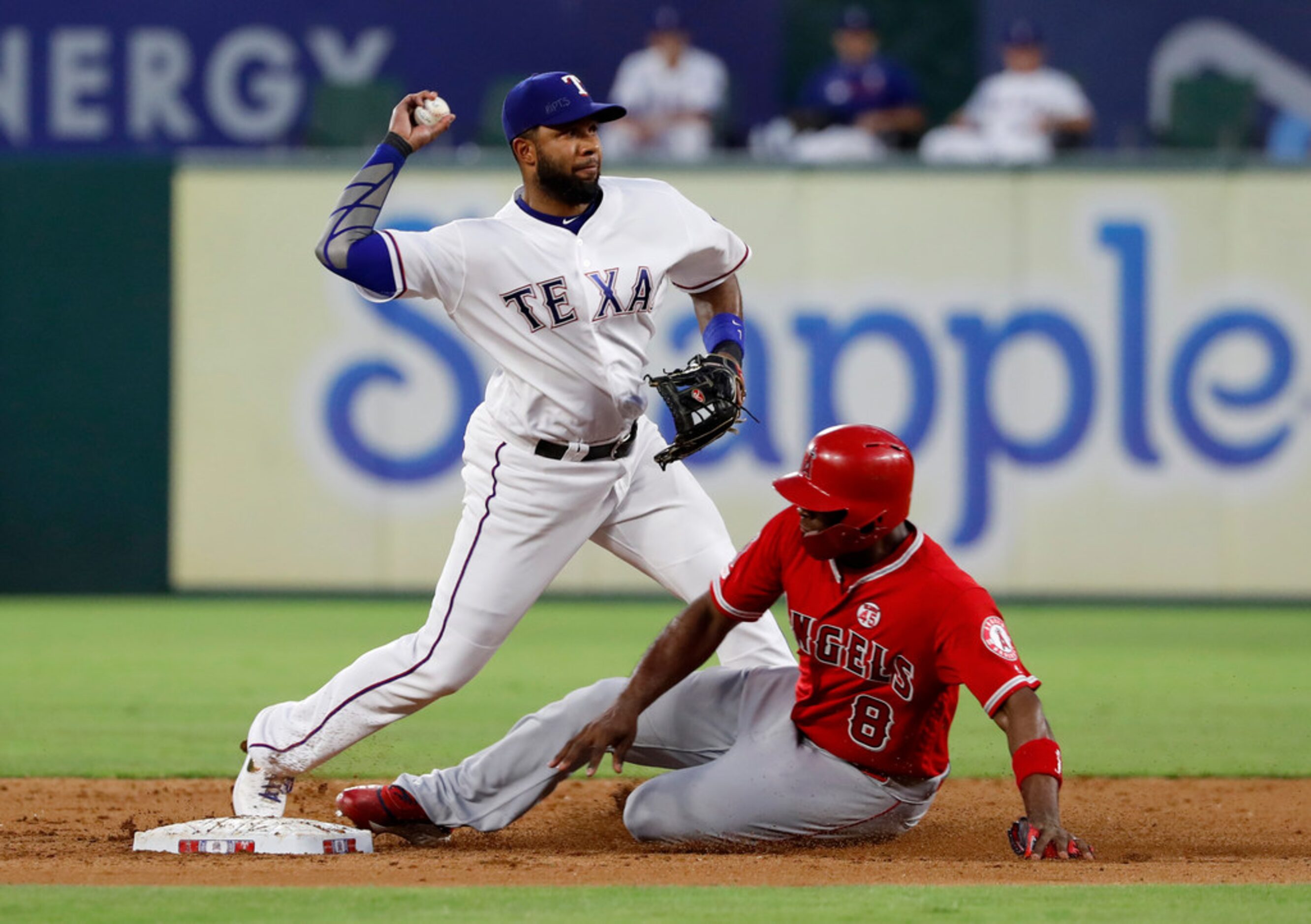 Texas Rangers shortstop Elvis Andrus throws to first for the double play after forcing out...