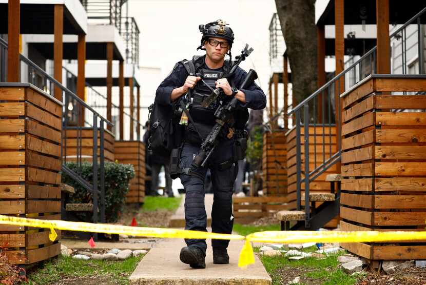 A SWAT officer leaves the scene where two children whose mother was found dead in their Far...
