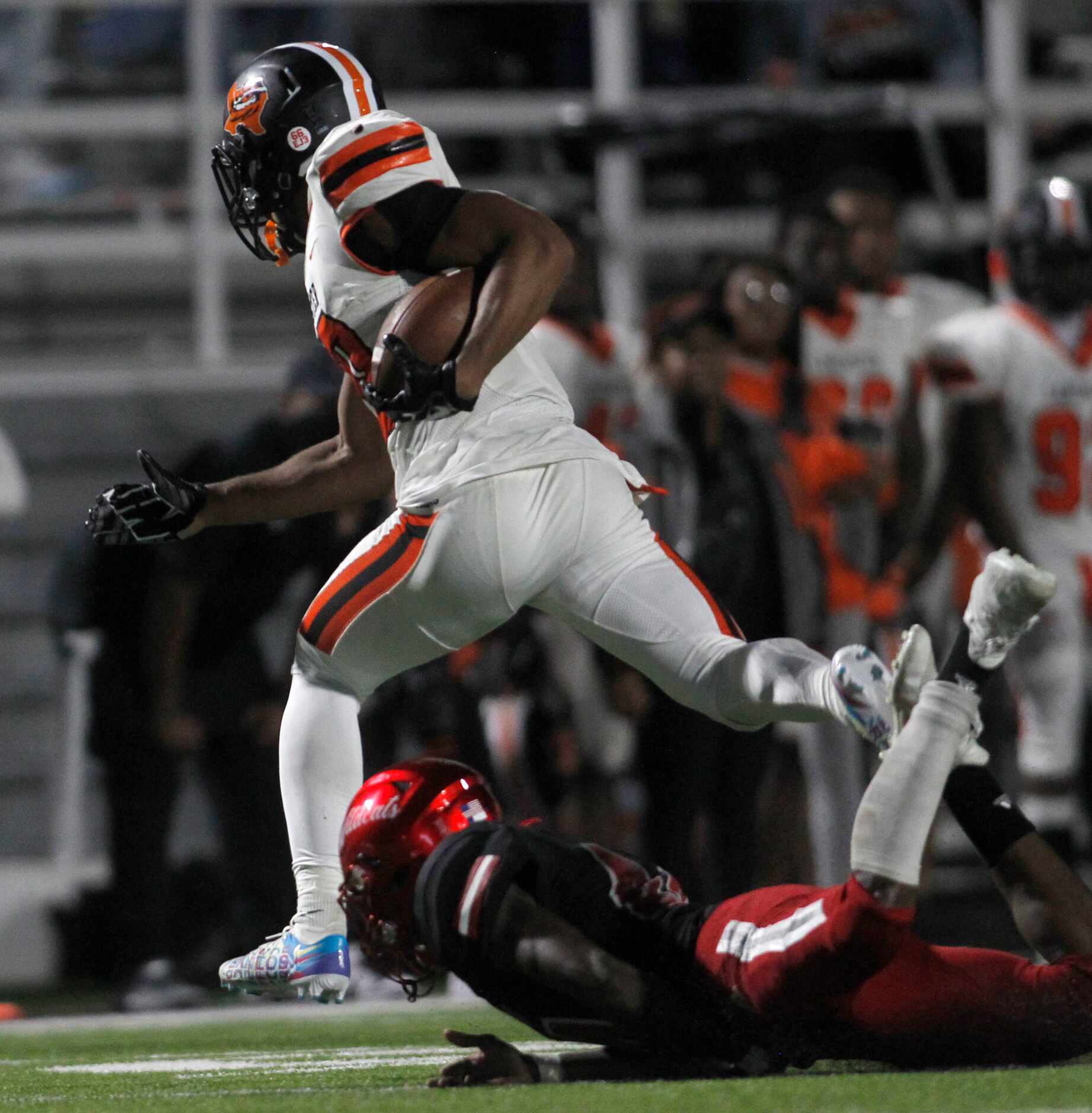 Lancaster running back Isaiah Broadway (20) leaps over the attempted tackle of Dallas...