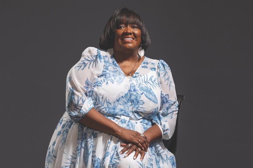 A photo of VR Small posing in a white and blue printed dress.