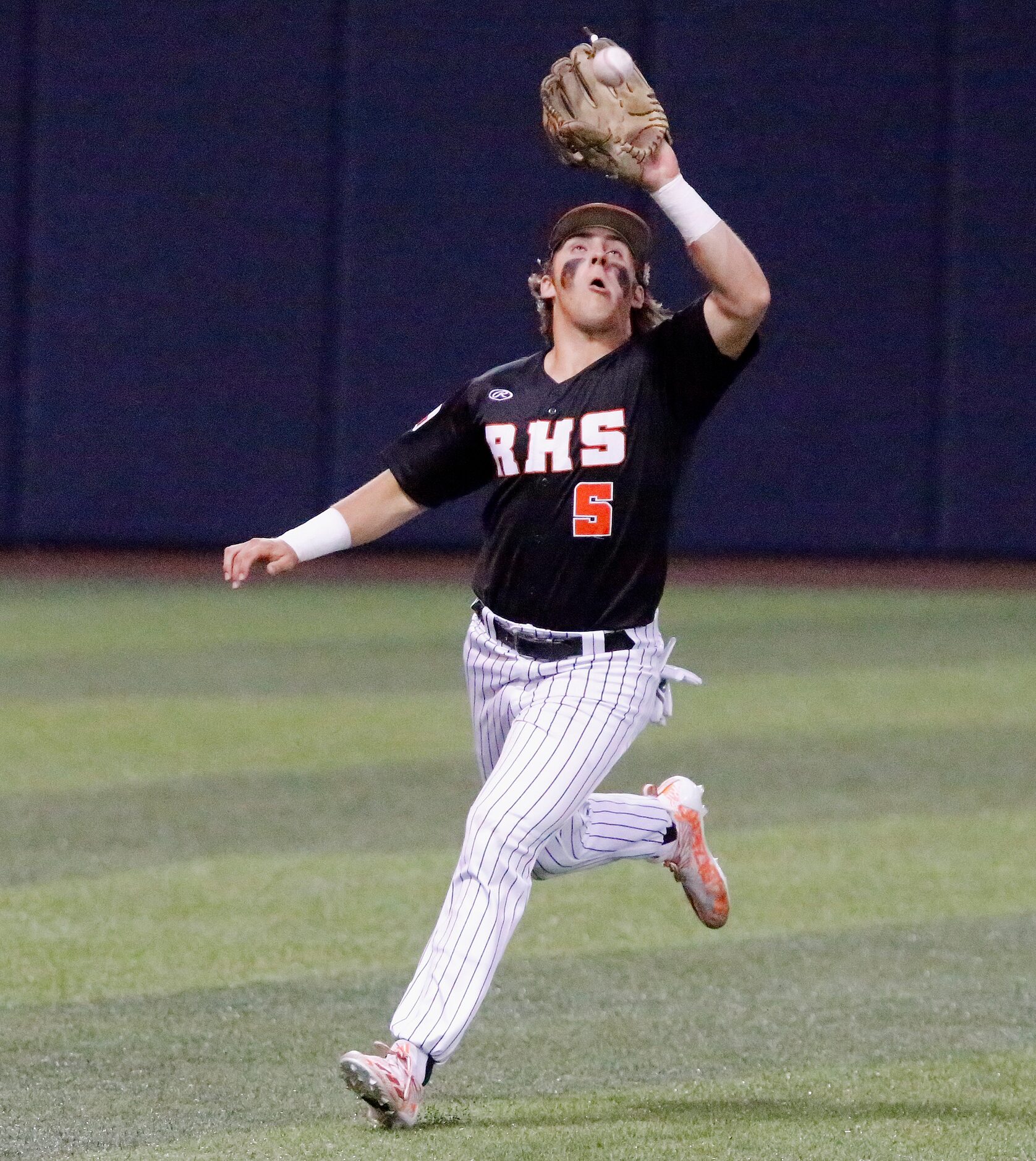 Rockwall left fielder Lake Bennett (5) makes a running catch for the out in the fourth...