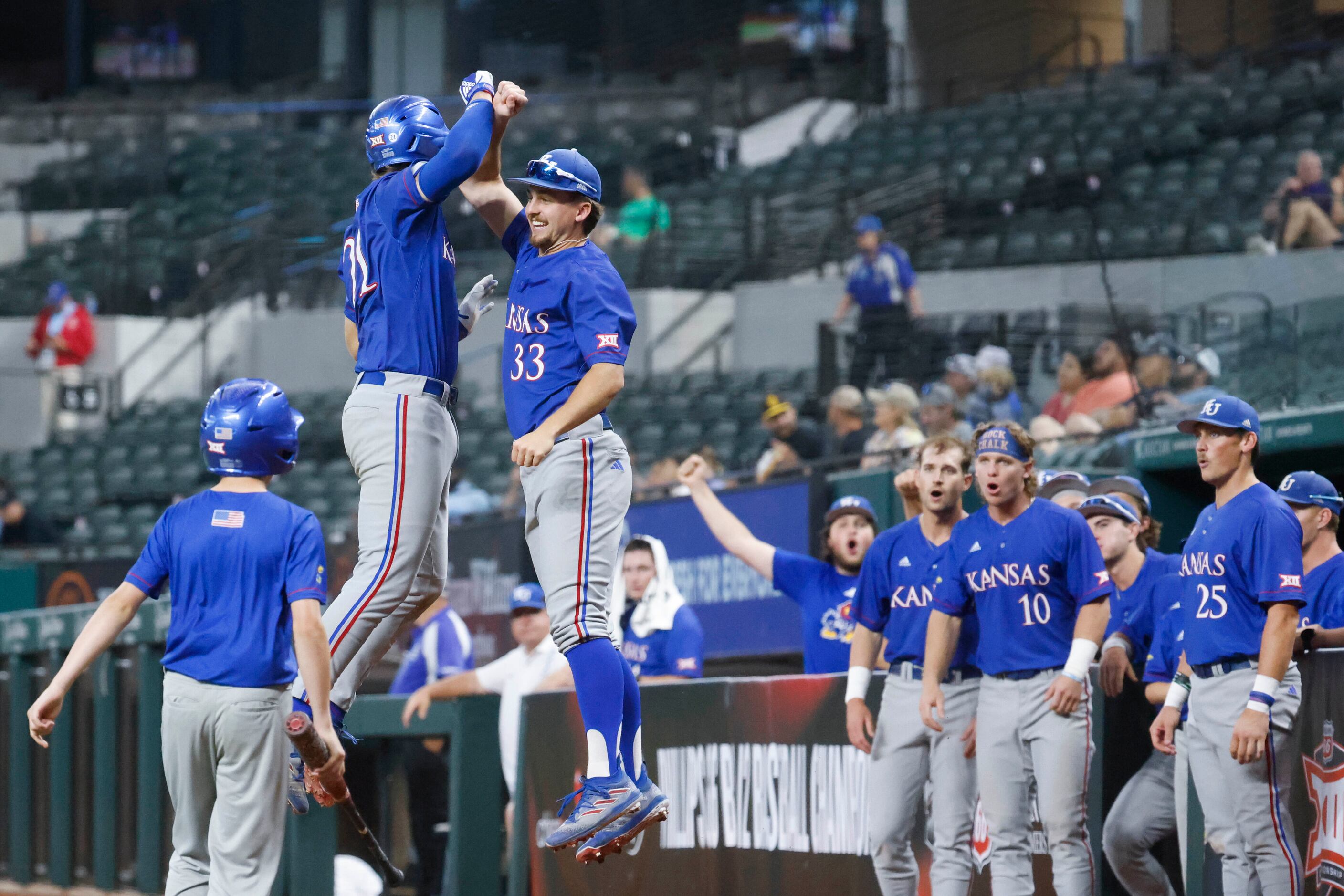 Kansas catcher Jake English (21) and utility Sam Hunt (33) cheers after a homer by English...