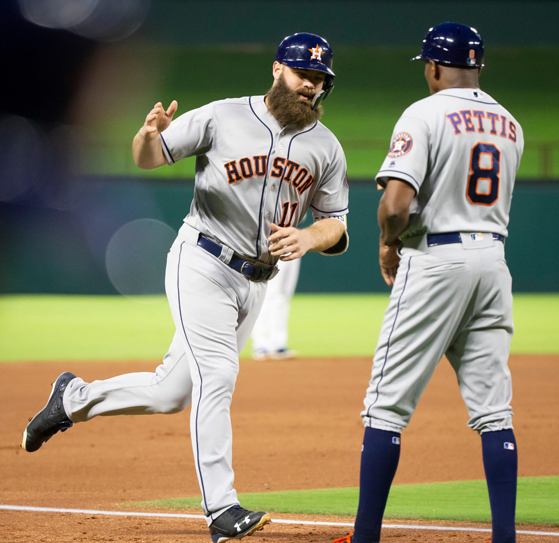 Houston Astros designated hitter Evan Gattis gets a hand from third base coach Gary Pettis...