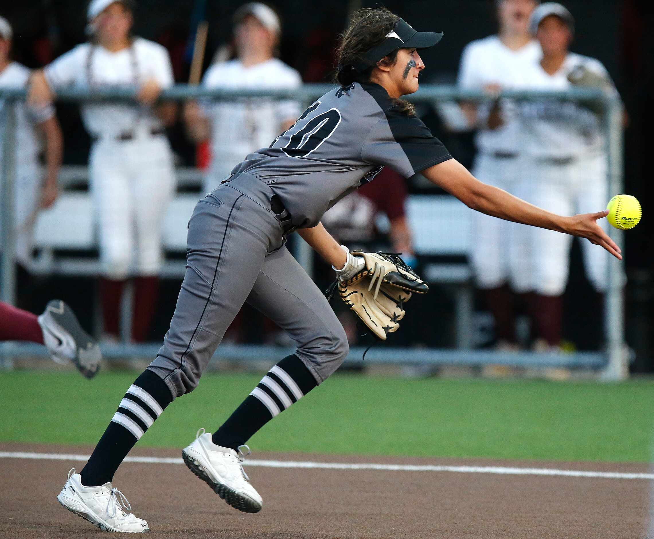 Denton Guyer High School first baseman Lilly Galaviz (10) tosses a bunt to home plate in the...