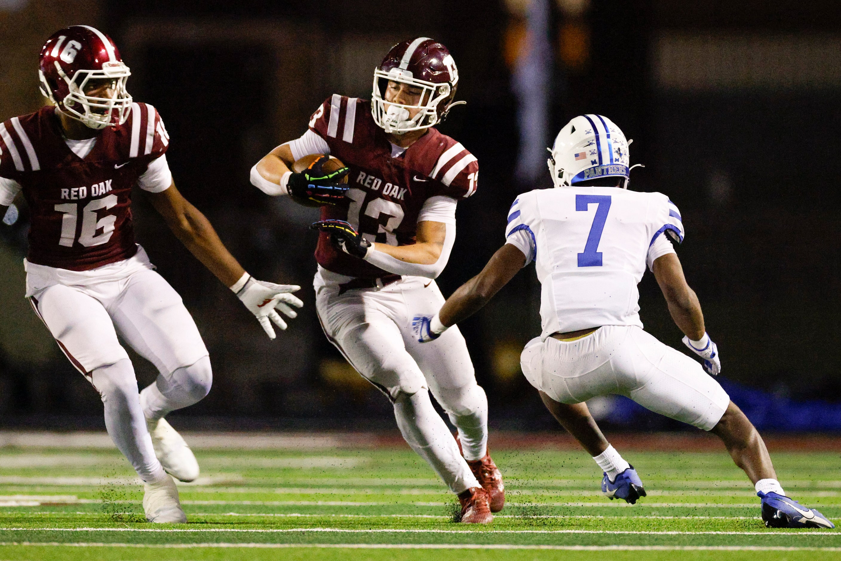 Red Oak running back Chris Martinez (13) avoids a tackle from Midlothian defensive back...