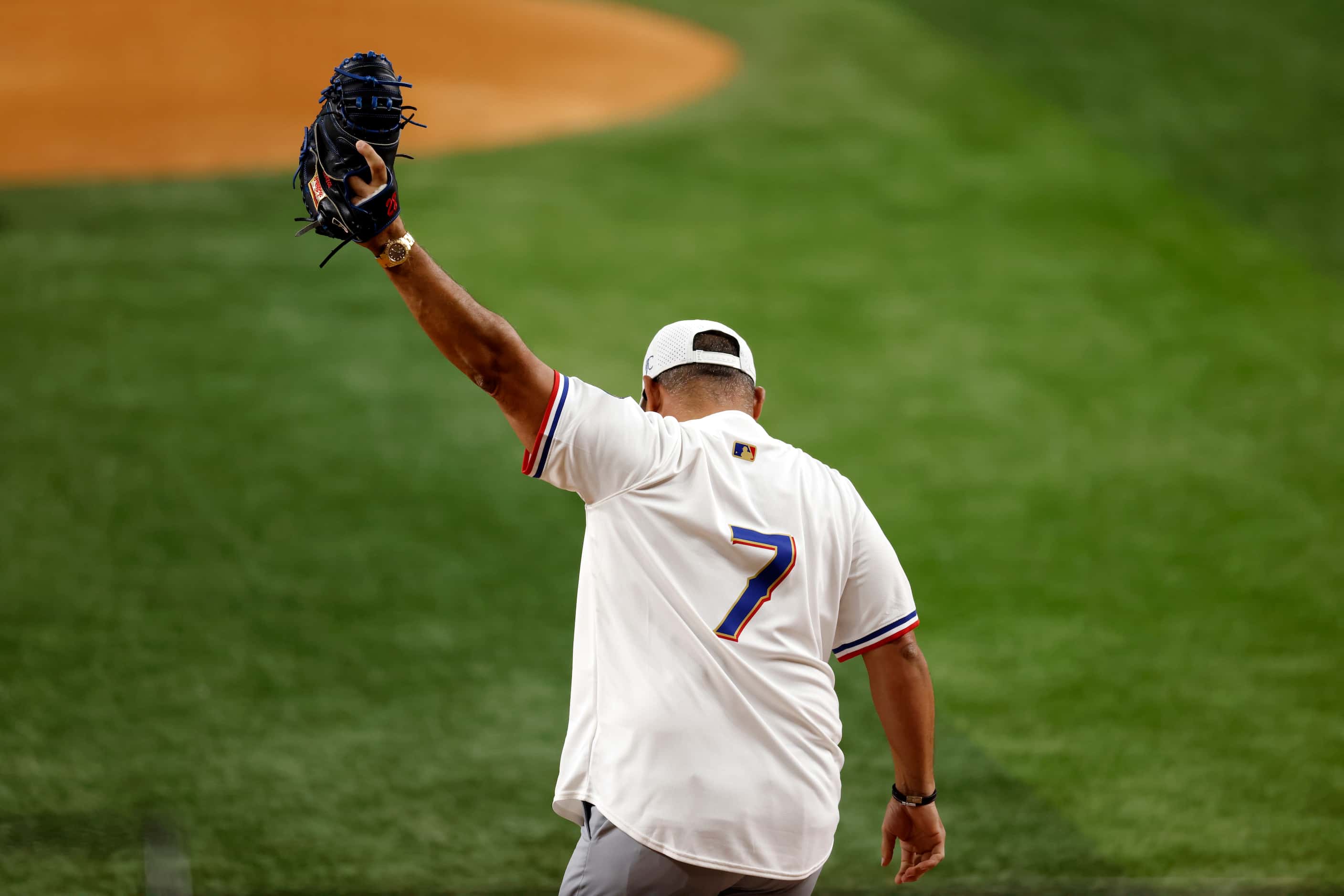 Hall of Famer Pudge Rodriguez raises his glove after catching the ceremonial first pitch...