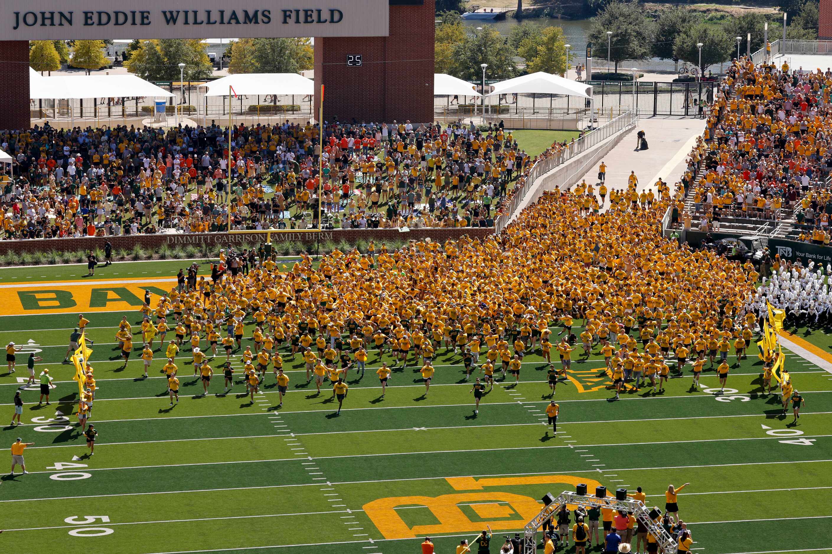 Baylor students run the field before an NCAA football game between Baylor University and...