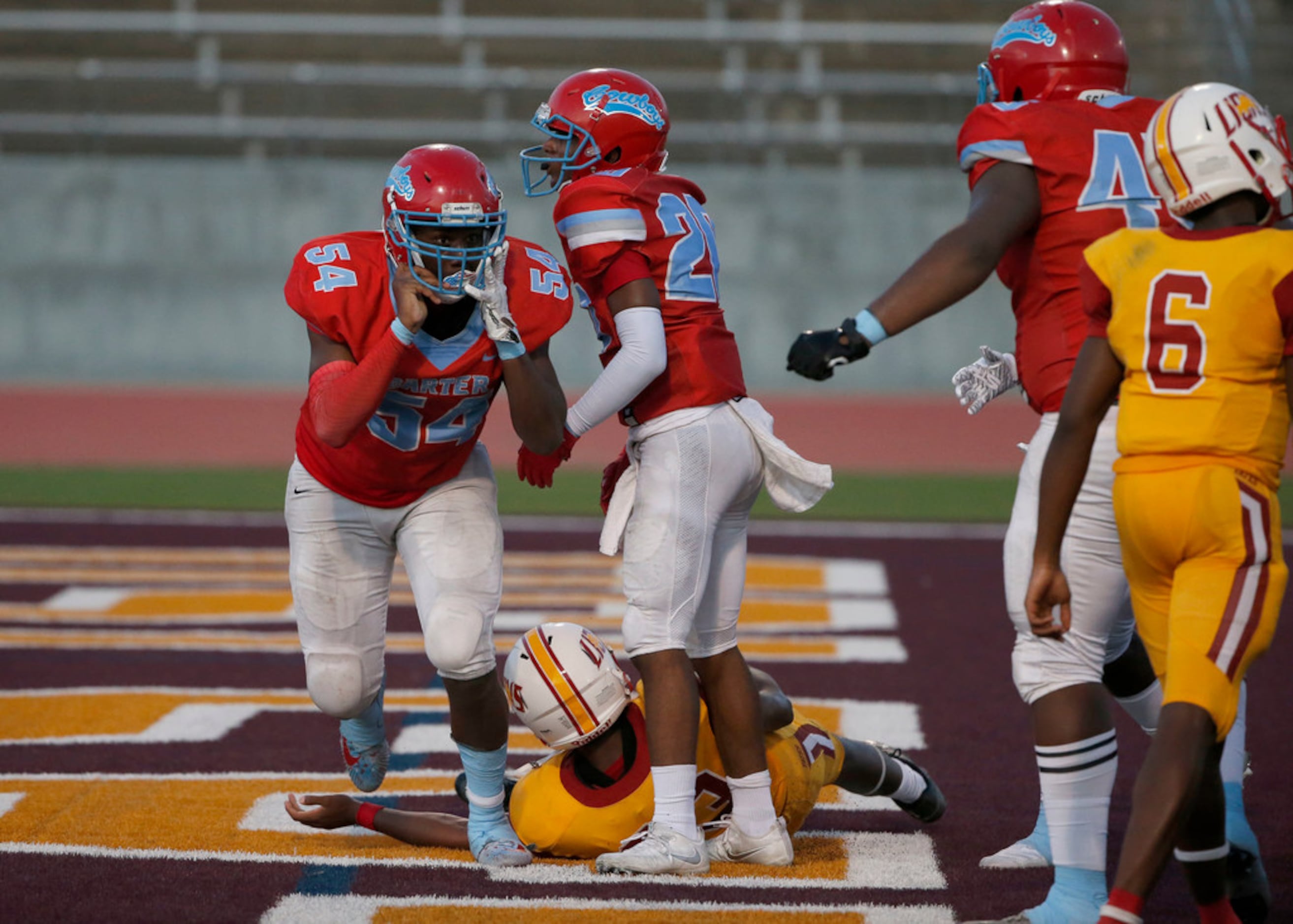 Dallas Carter players Randy Anthony (54) and Jv'Quavion Vinson (20) celebrate their safety...