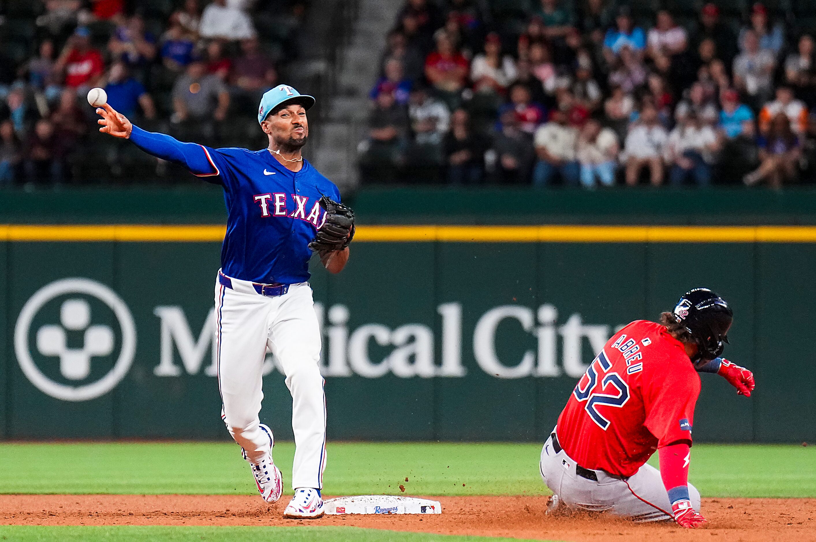 Texas Rangers second baseman Marcus Semien turns a double play over the Boston Red Sox...