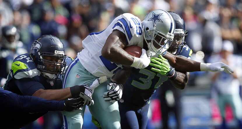 Dallas Cowboys running back DeMarco Murray (29) is wrapped up by Seattle Seahawks defensive...