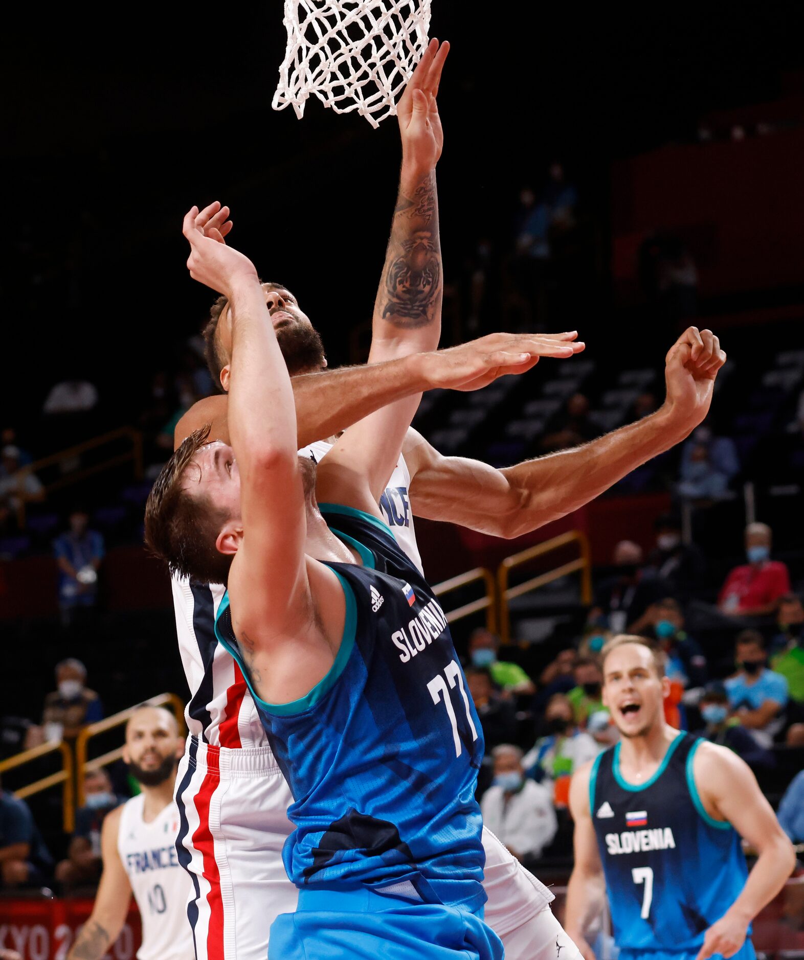 Slovenia’s Luka Doncic (77) is hit in the face by France’s Rudy Gobert (27) during the...