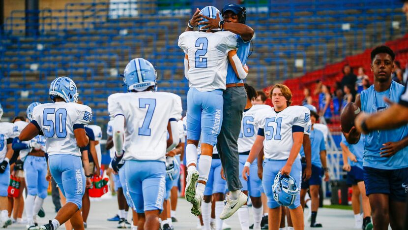 Emerson Mavericks wide receiver Kylen Evans (2) celebrates a touchdown with a coach during...