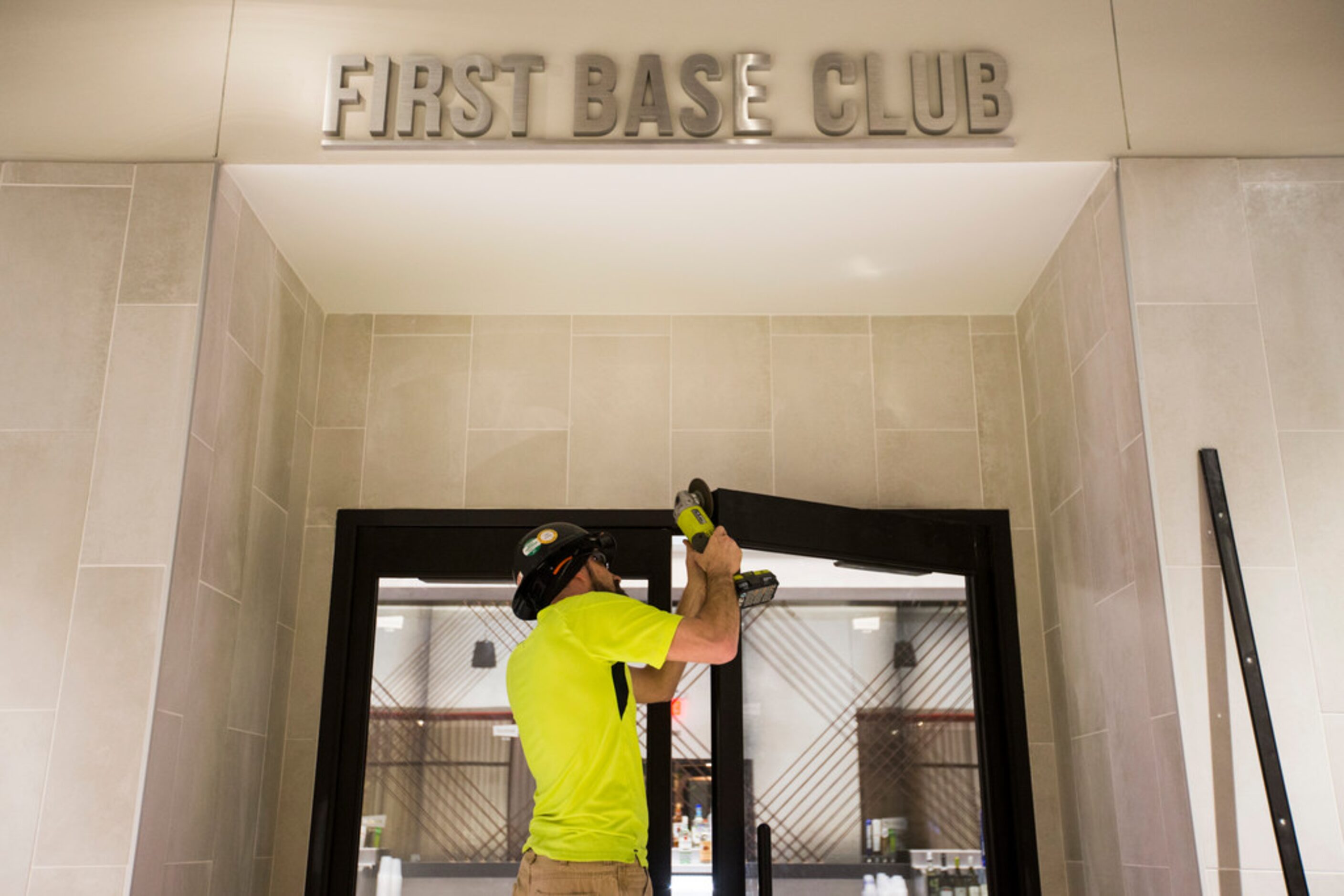 A worker grinds the corner of a door to the First Base Club on the lower concourse during an...