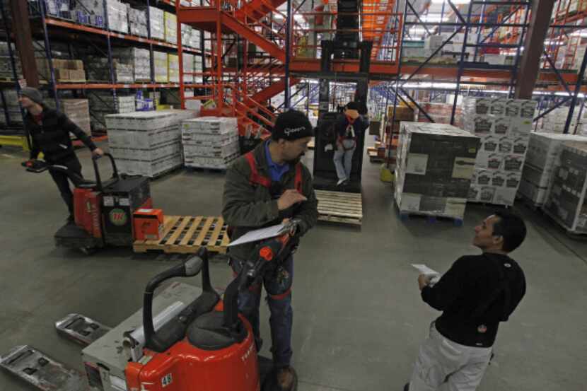 Noe Martinez (center) and Carlos Alvarado discuss shipments on the floor of Glazer's...