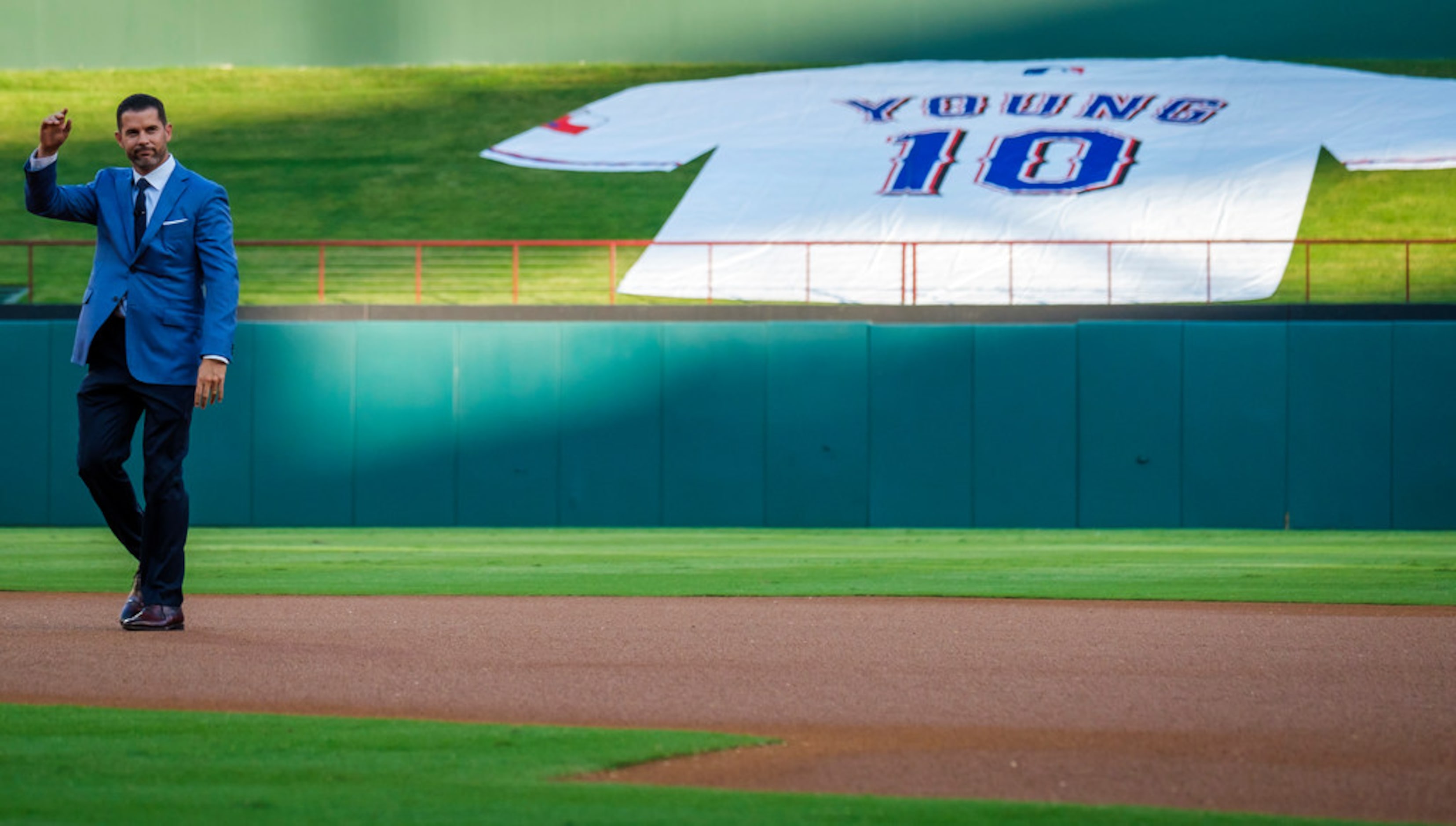 Michael Young waves to the crowd during ceremonies to retire Young's No. 10 before a game...