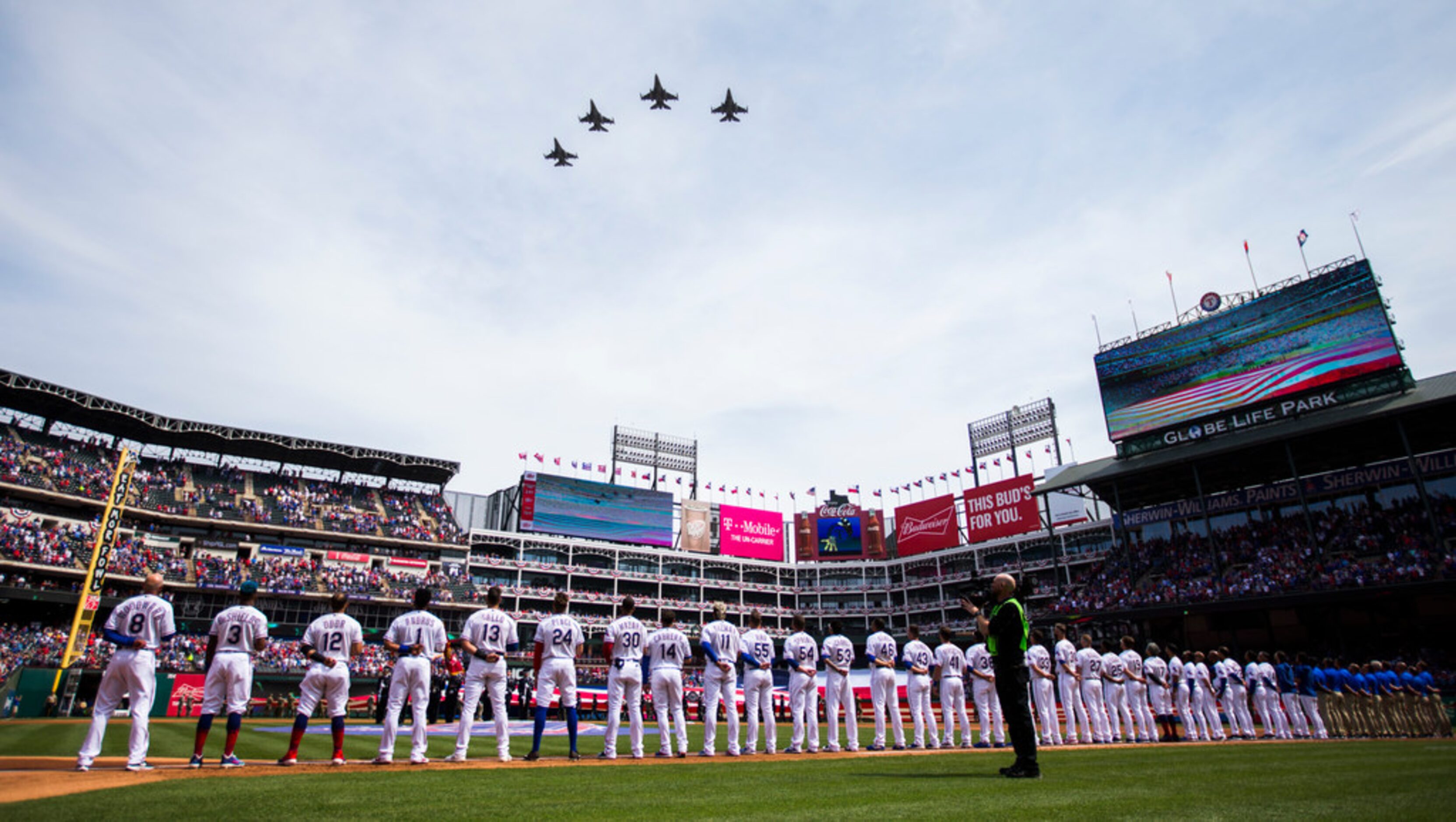 F-16 jet fighters fly over the Texas Rangers lineup before an opening day MLB game between...