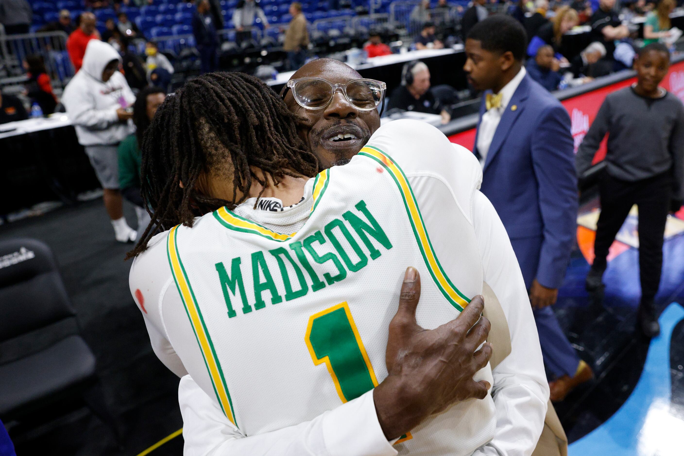 Madison head coach Damien Mobley hugs Madison guard Pierre Hunter (1) after winning the...