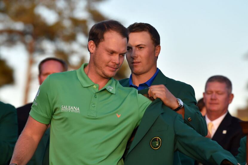 Masters champion Danny Willett gets the Green Jacket from Jordan Spieth following the final...