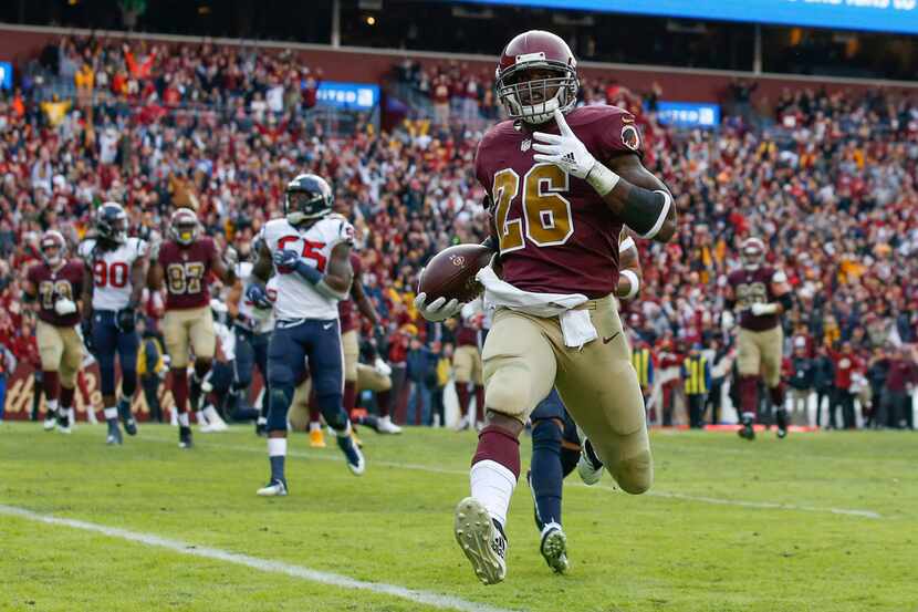 Washington Redskins running back Adrian Peterson (26) carries the ball into the end zone for...