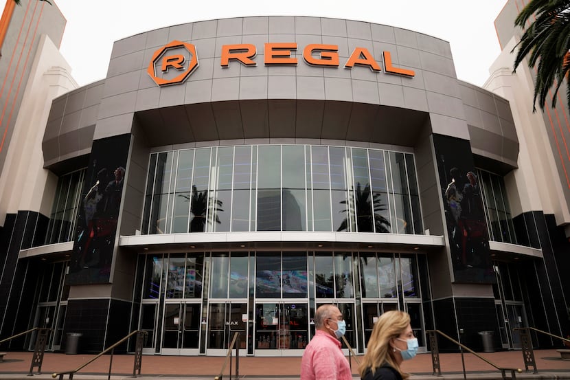 Two shoppers walk past a Regal movie theater in Irvine, Calif. in September.